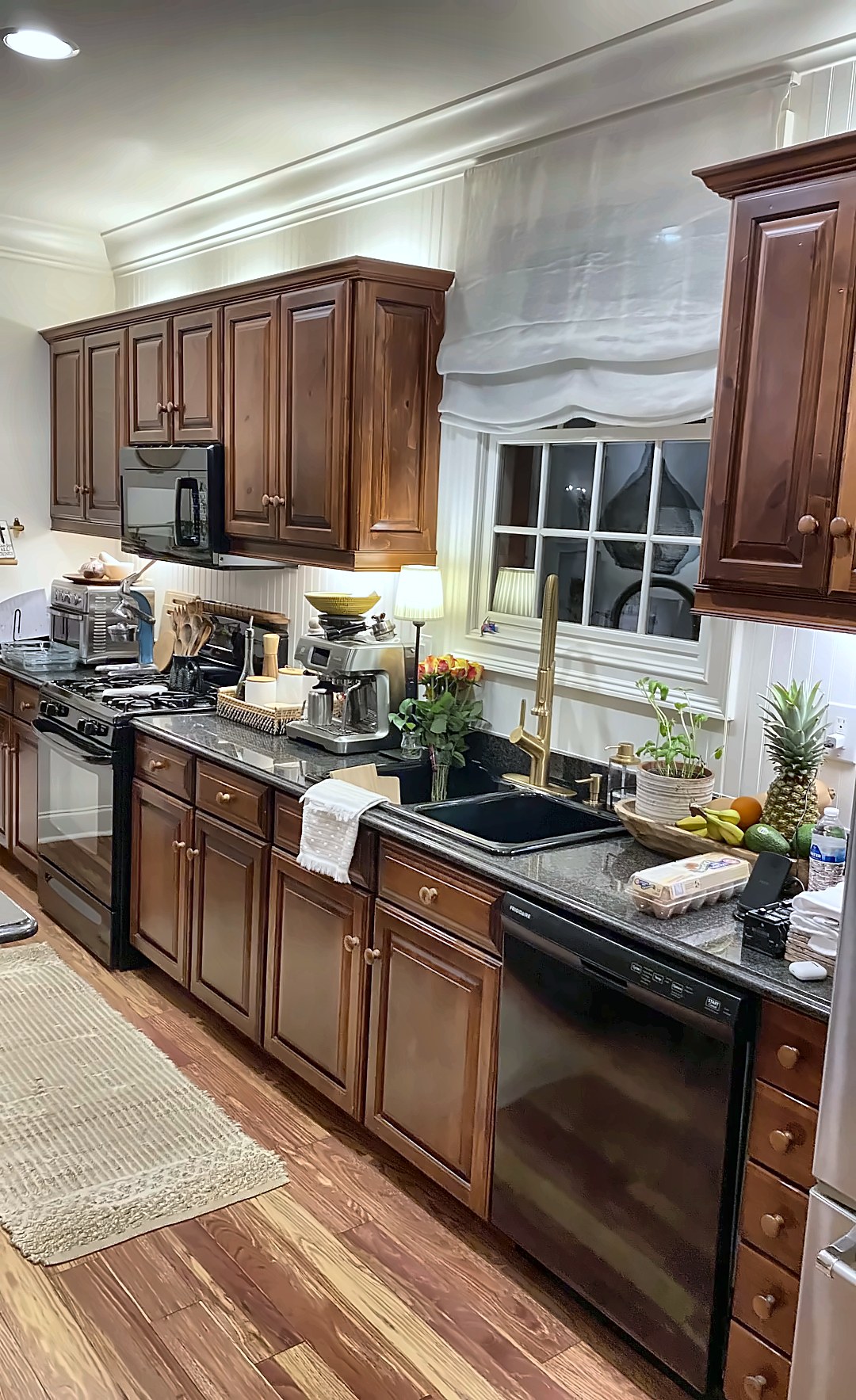 Before: dark wood cabinets and black appliances