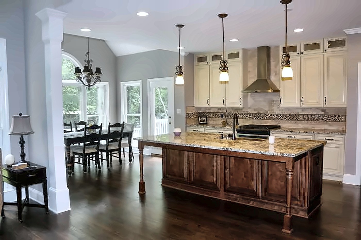 Bright open kitchen with cream cabinets, a stained wood island and granite counters